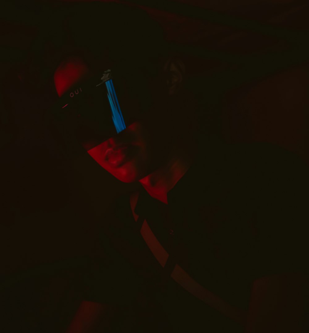 a man in a dark room with a cell phone in his hand