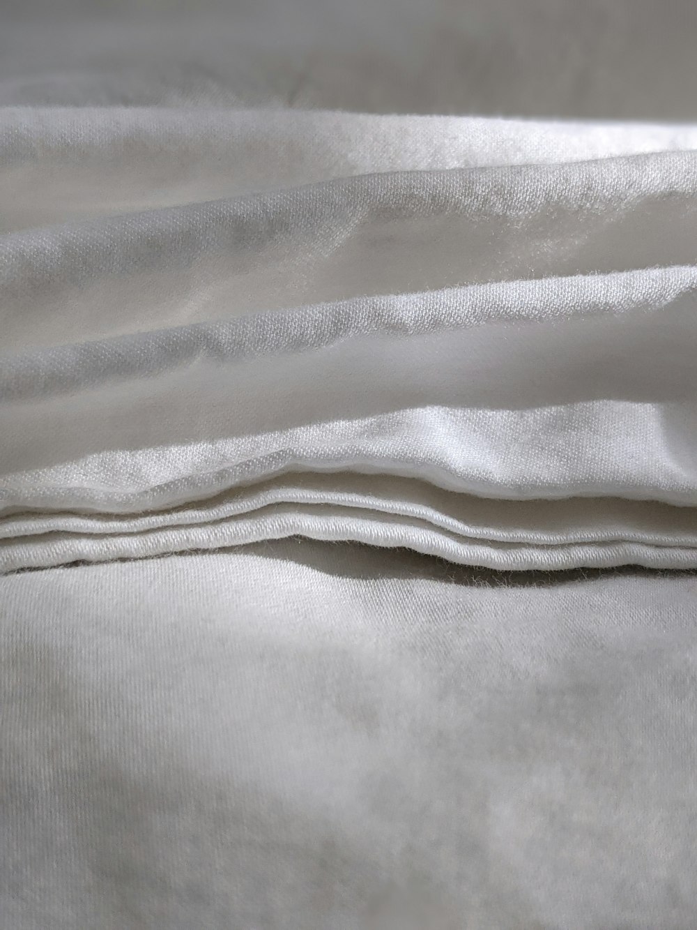a close up of a white sheet on a bed