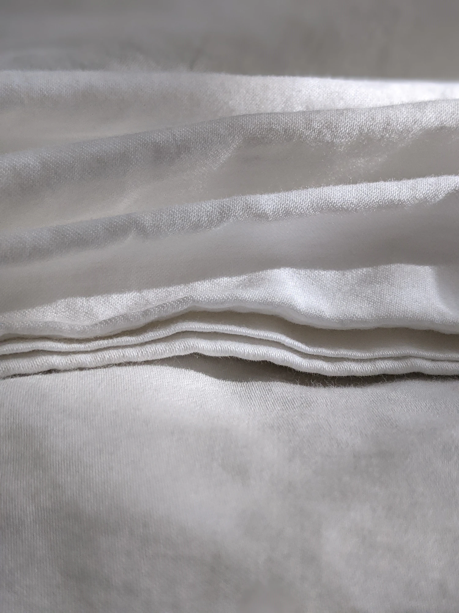 A stack of folded white linen seen close up
