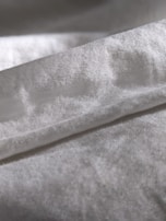 Close-up of luxurious fabric textures in soft lighting, highlighting the fine weave and sheen.