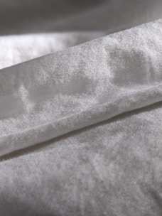 Close-up view of gentle, textured fabric in earthy tones folded neatly on a table.