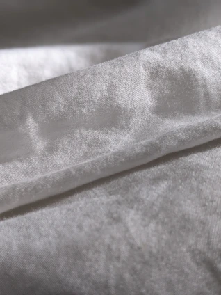 Close-up of soft fabric textures from both men's and women's clothing, highlighting quality materials.