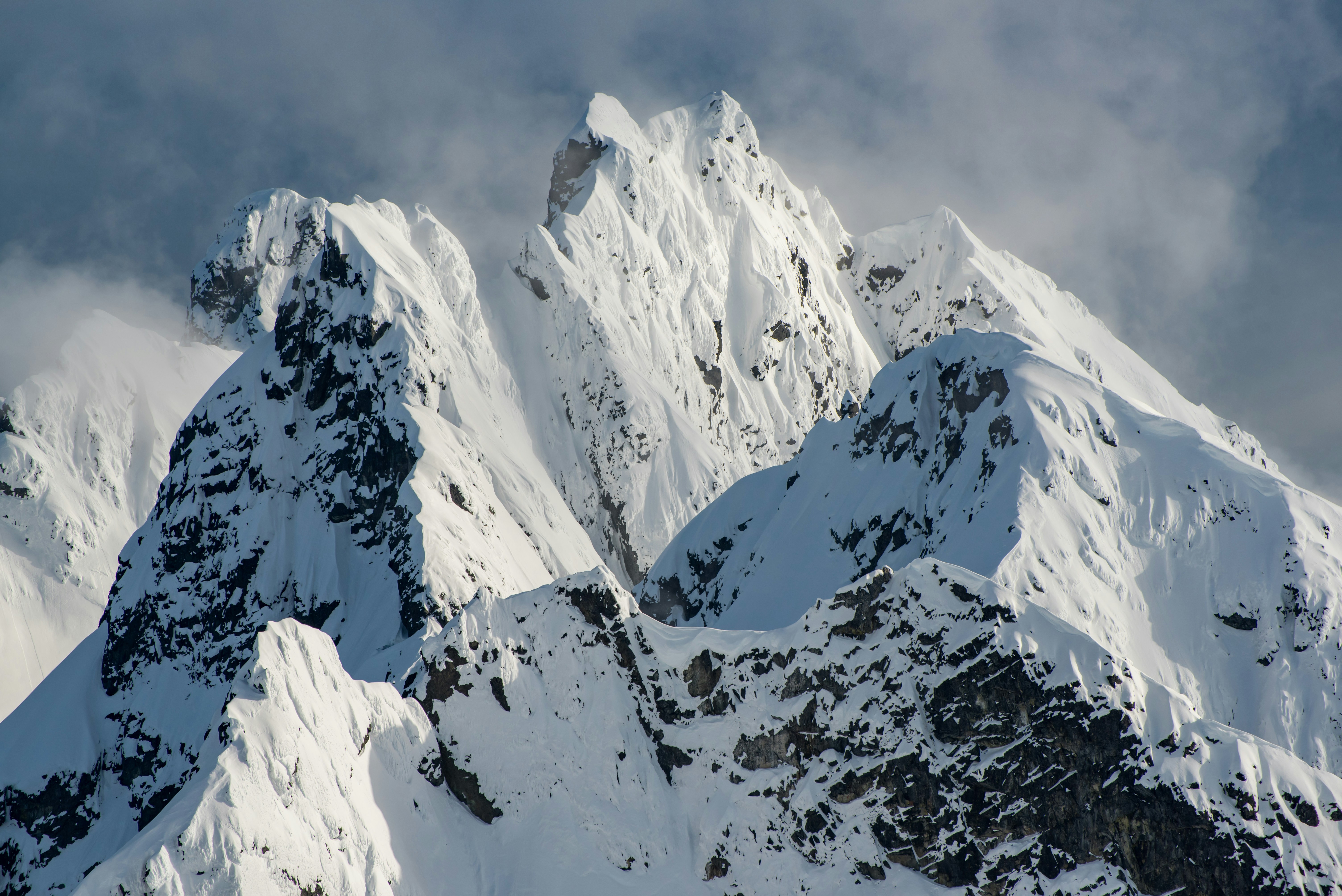 uma grande montanha coberta de neve sob um céu nublado
