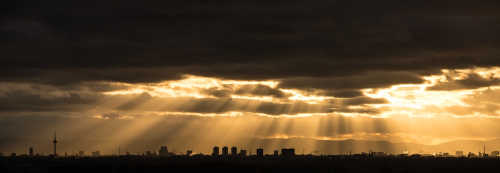 the sun is shining through the clouds over a city