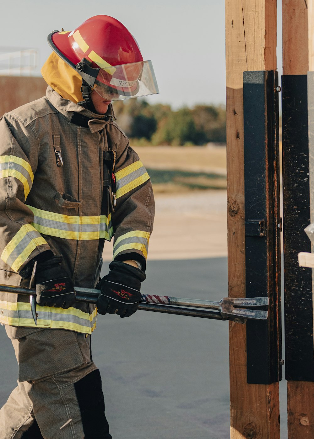 Un pompiere in tuta antincendio che tiene una manichetta antincendio