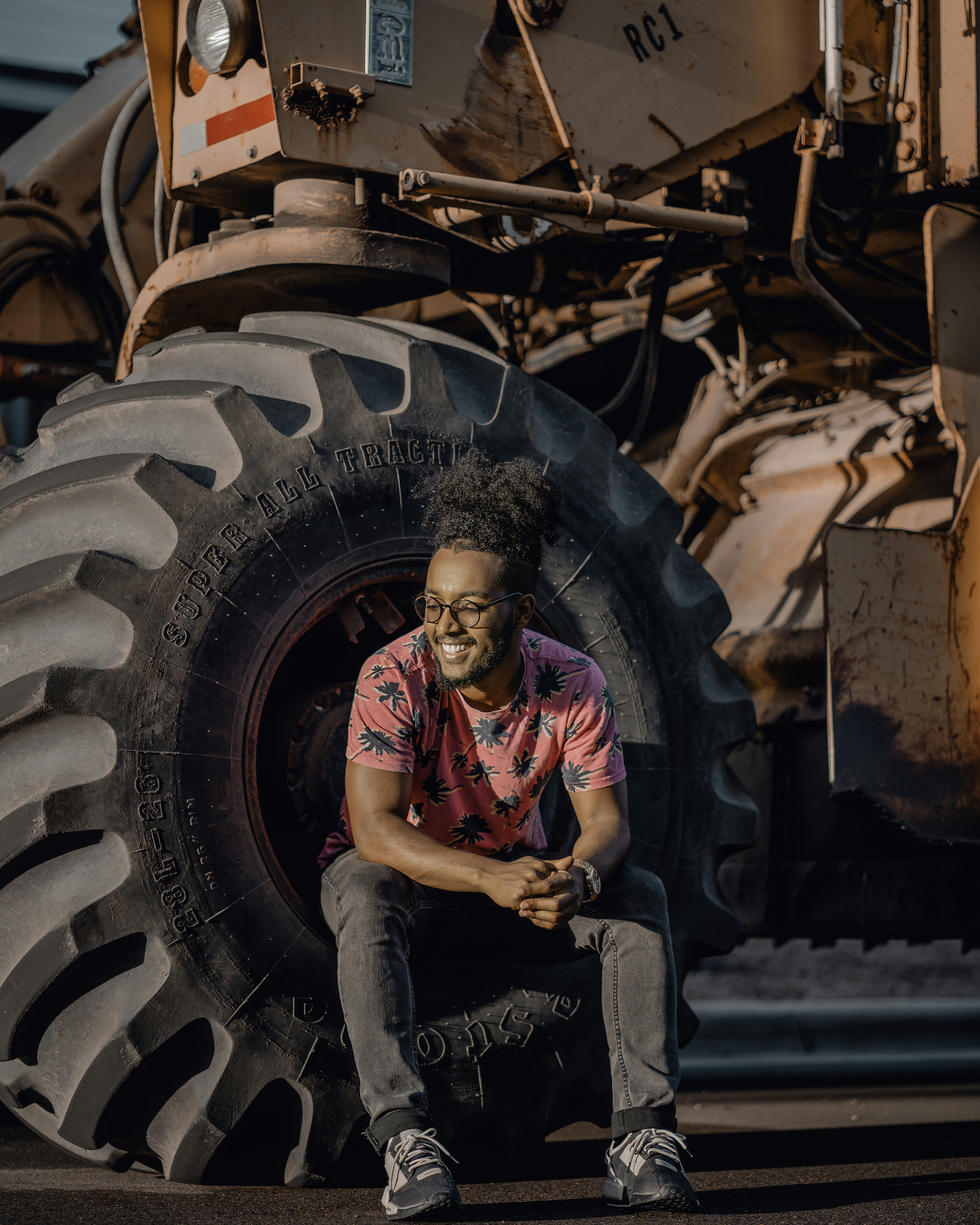Un hombre sentado frente a un gran tractor