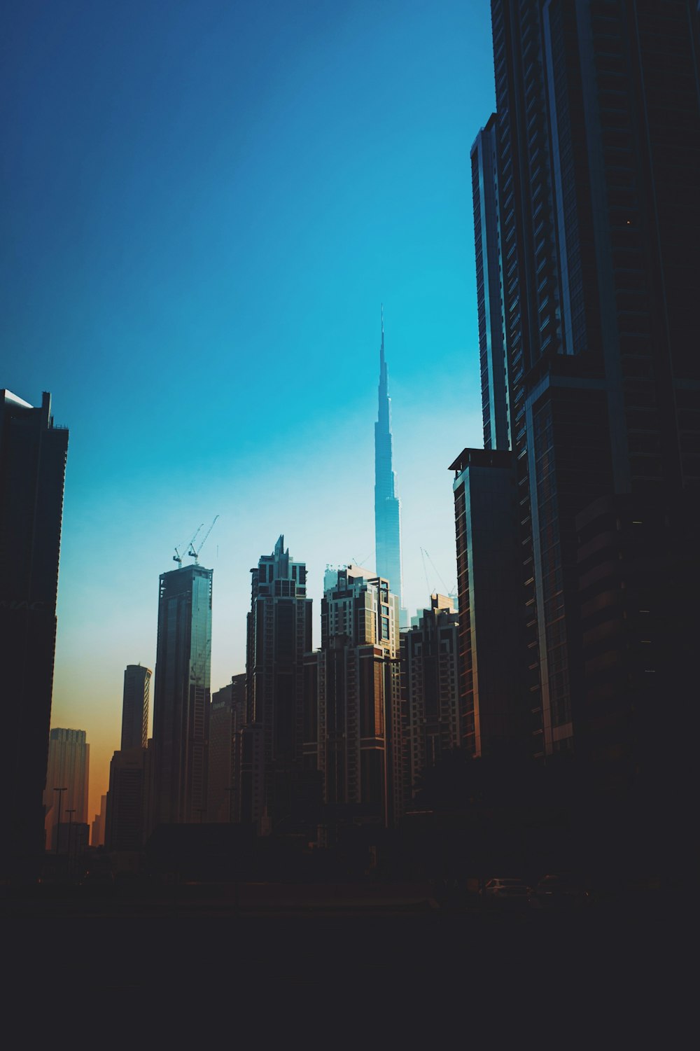 a city skyline with tall buildings and a blue sky