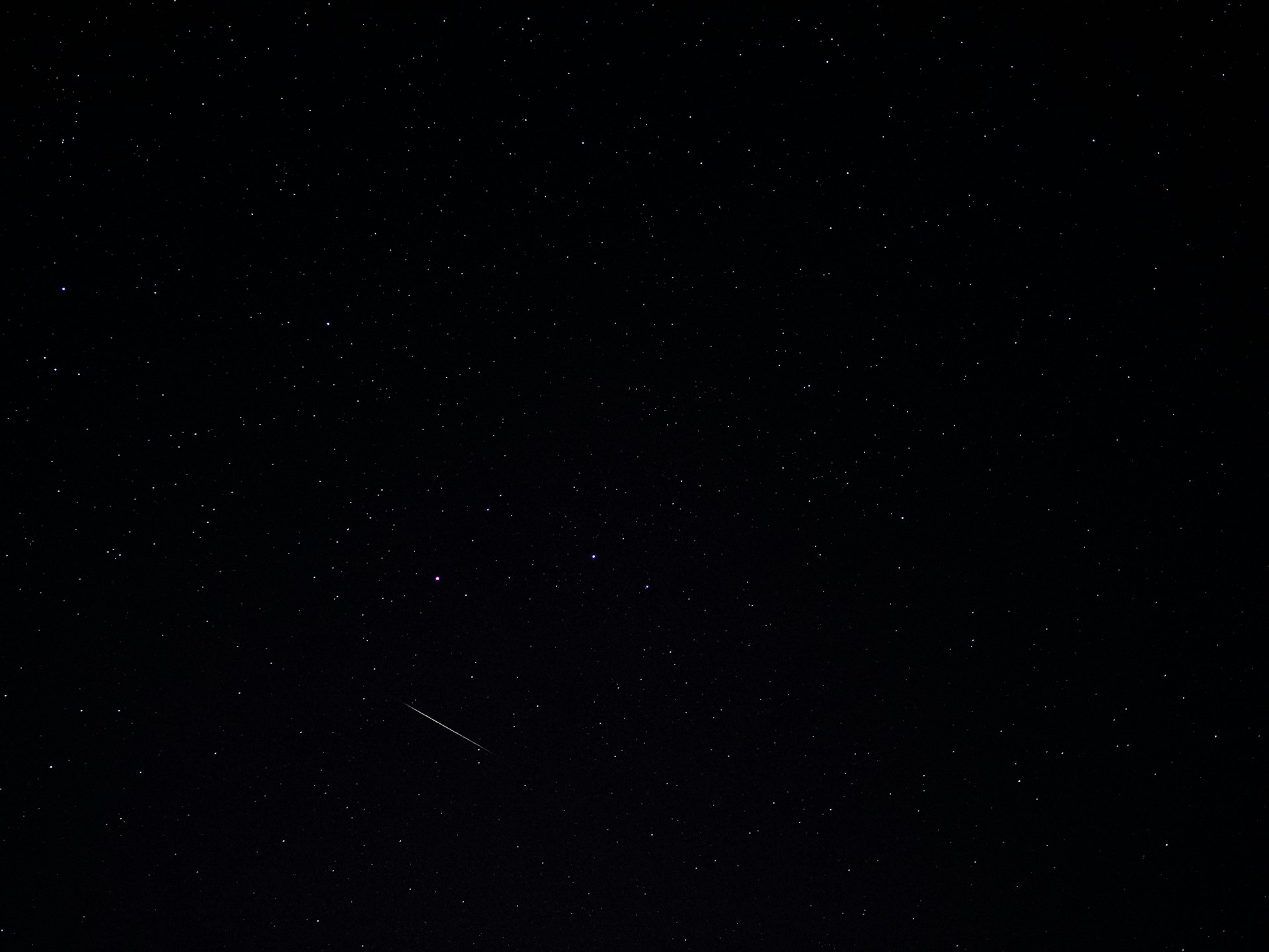 a night sky with stars and a shooting star
