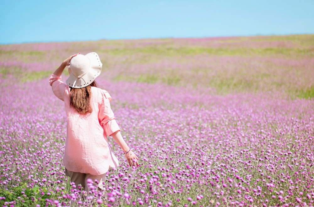 a little girl walking through a field of purple flowers