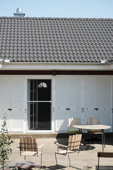 a patio with a table, chairs, and sliding doors