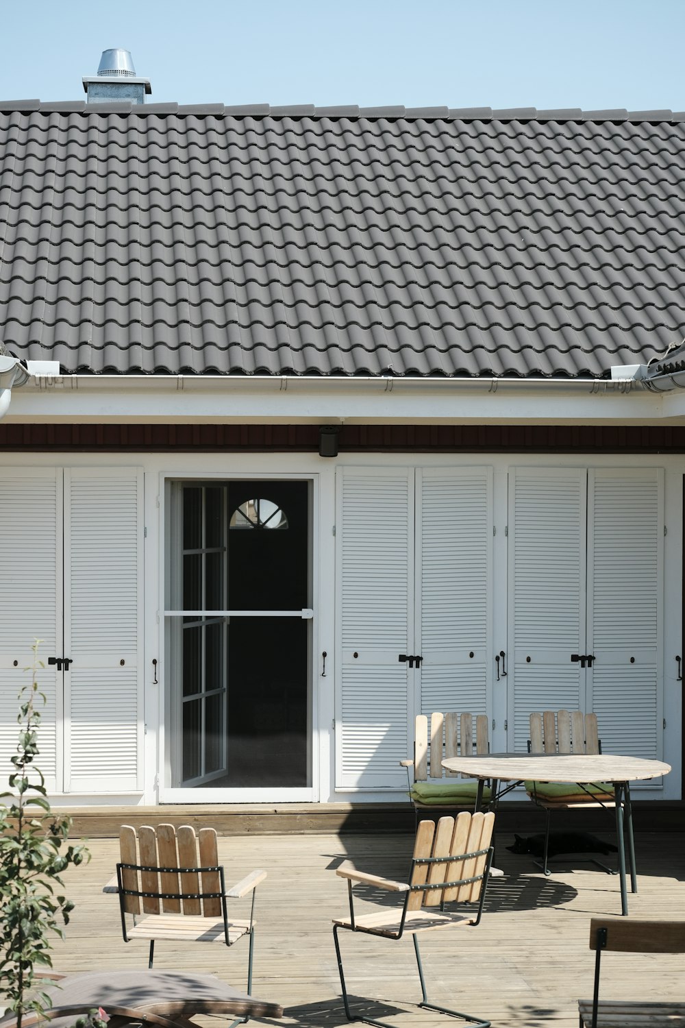 a patio with a table, chairs, and sliding doors