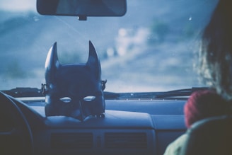 a batman mask sitting on the dashboard of a car