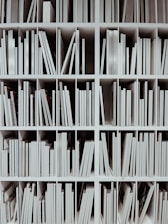 a book shelf filled with lots of white books