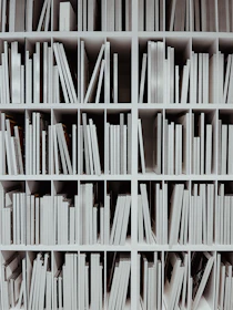 a book shelf filled with lots of white books