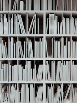 a book shelf filled with lots of white books