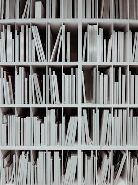 a book shelf filled with lots of white books