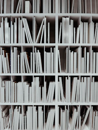 a book shelf filled with lots of white books