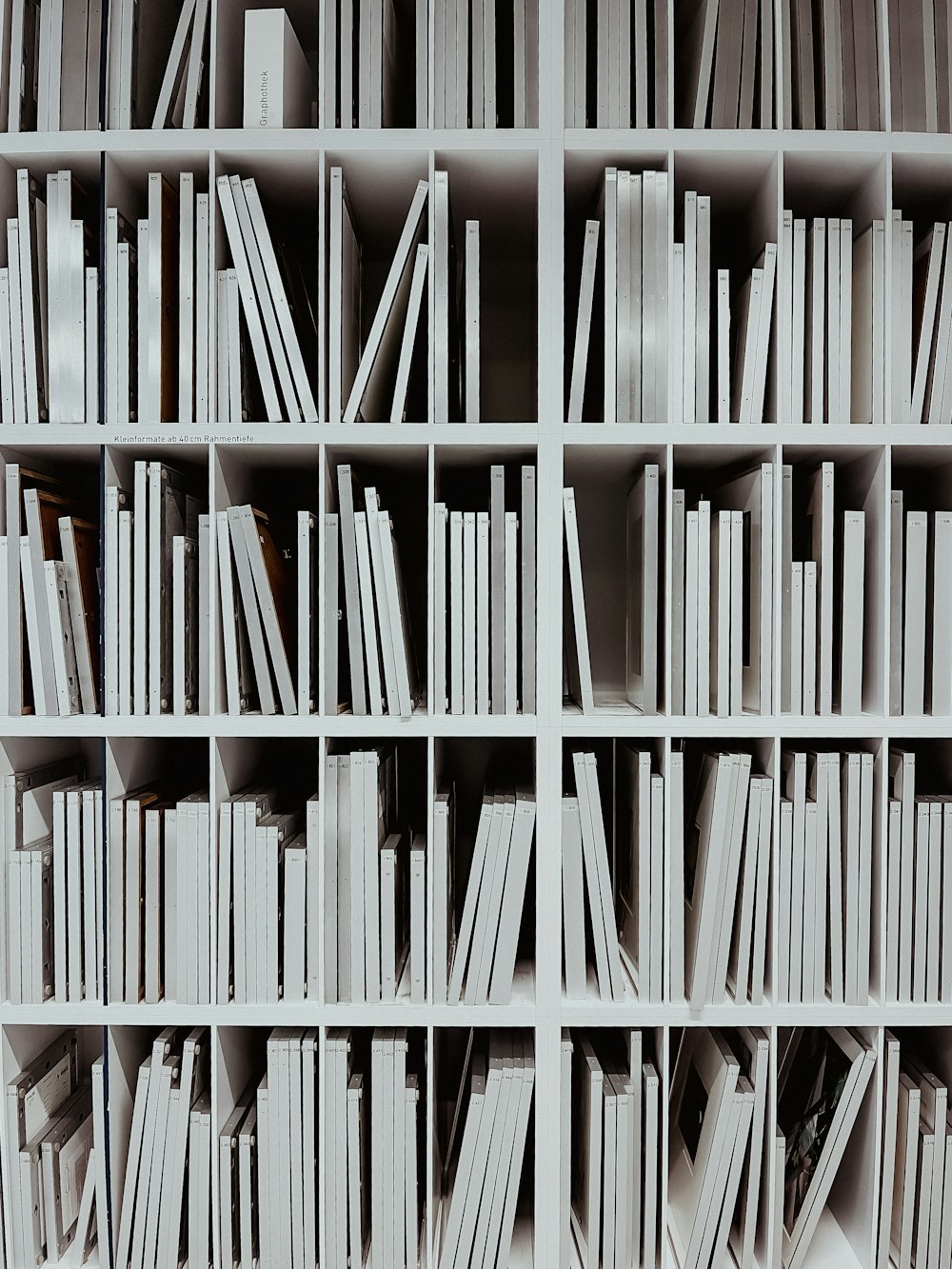 ein Bücherregal gefüllt mit vielen weißen Büchern