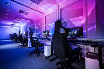 a room filled with lots of computer desks and chairs