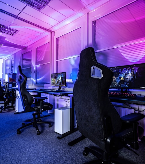 a room filled with lots of computer desks and chairs