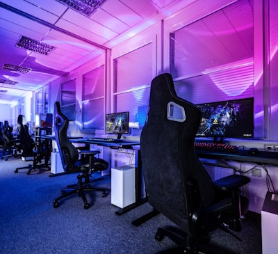 a room filled with lots of computer desks and chairs