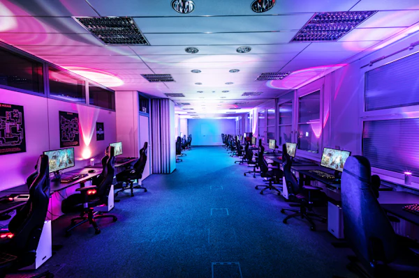 A wall of competitive gaming monitors in a darkened esports arena
