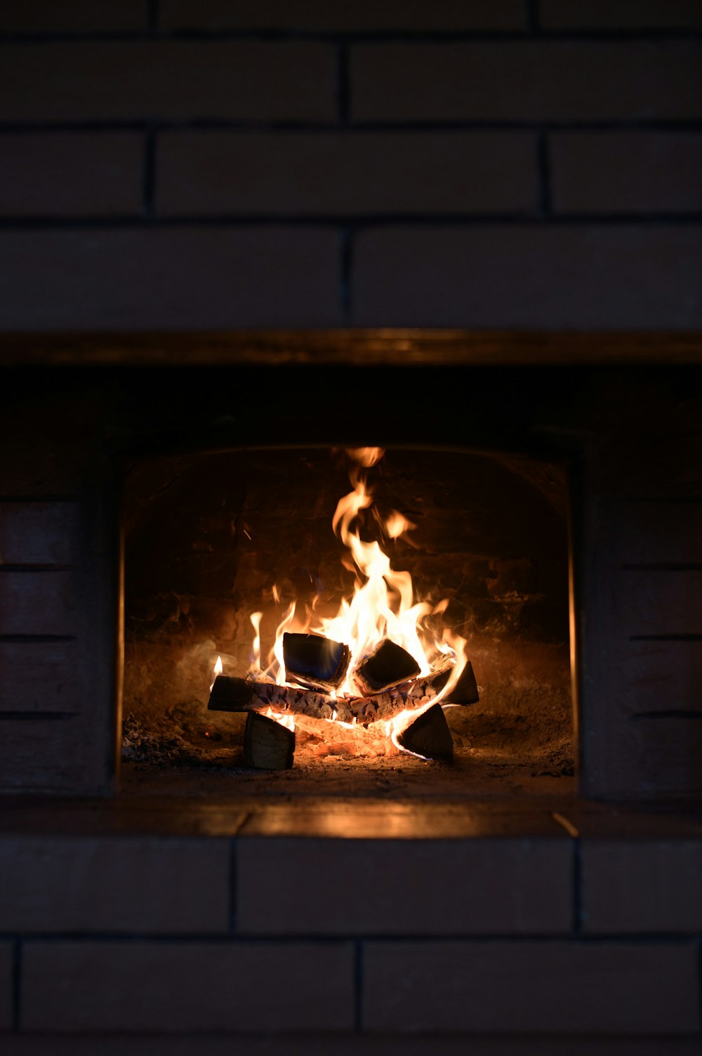 a fire burning inside of a brick oven