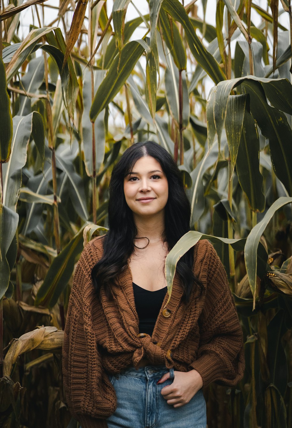 a woman standing in front of a corn field