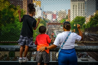 a group of people standing next to each other near a fence