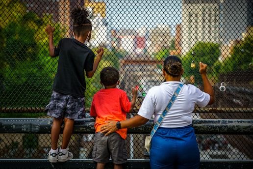 a group of people standing next to each other near a fence