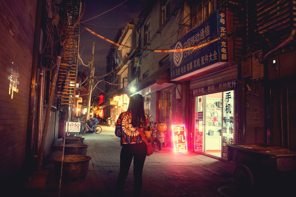 a woman standing on a city street at night