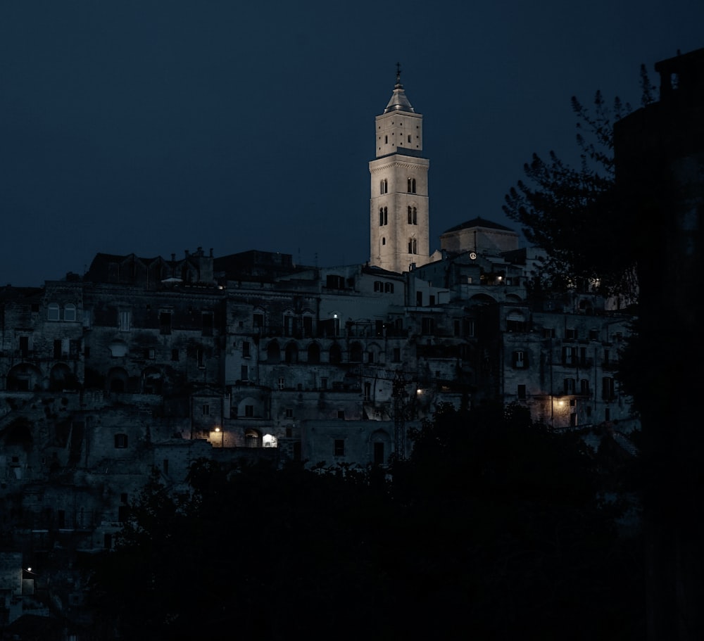 Una grande torre dell'orologio che domina una città di notte