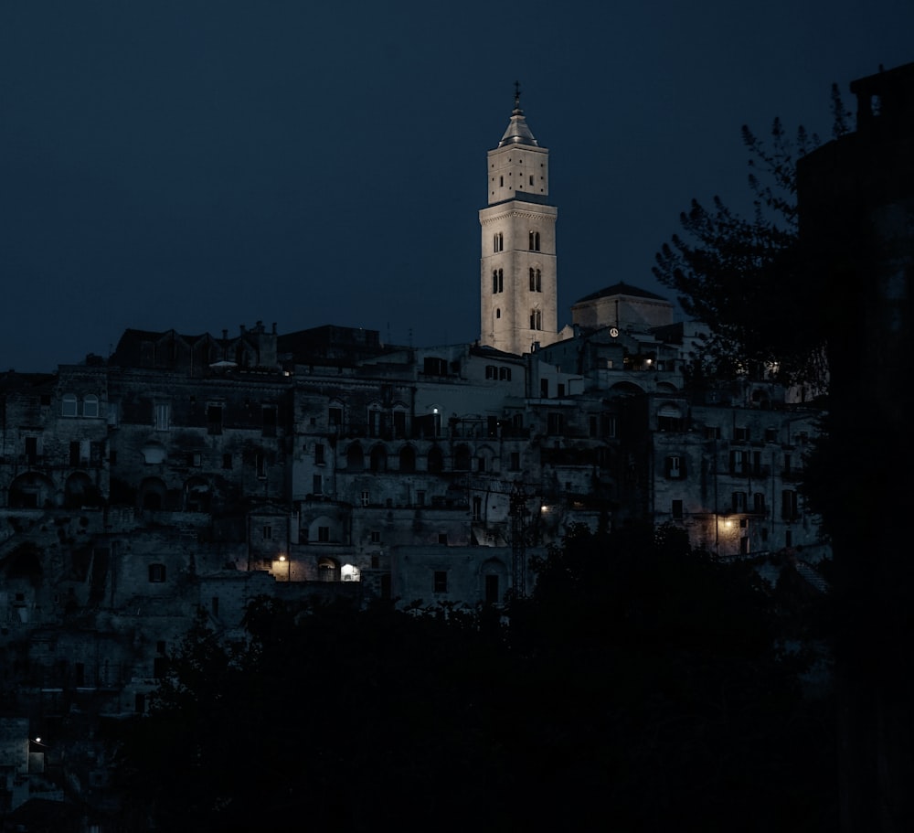 a large clock tower towering over a city at night