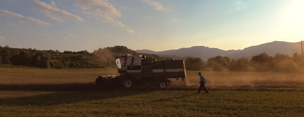 a person walking in a field next to a tractor