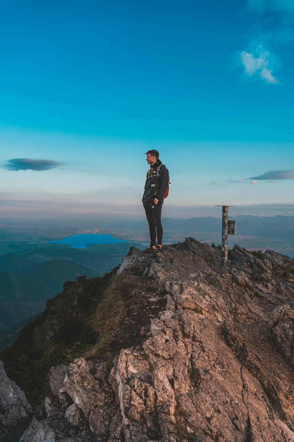 a man standing on top of a mountain with a backpack