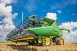 a large green tractor with a bale of hay on it's back