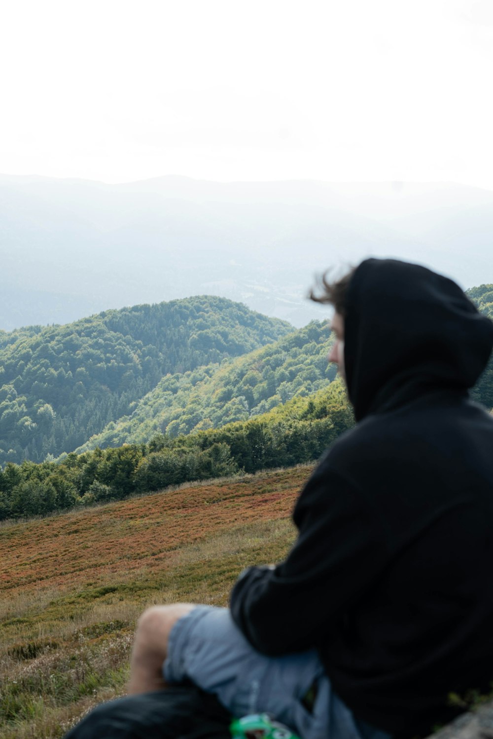 a man sitting on top of a wooden bench