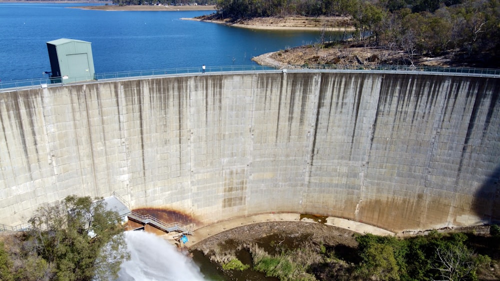 an aerial view of a dam with a lake in the background