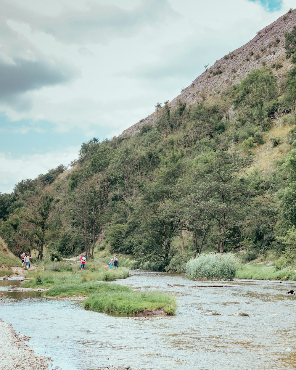 a group of people walking along a river