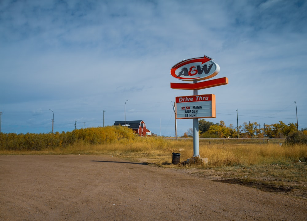 a red and white sign sitting on the side of a road