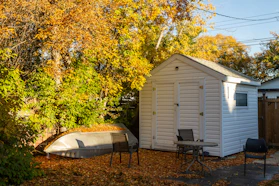 a small white shed with a boat in the yard