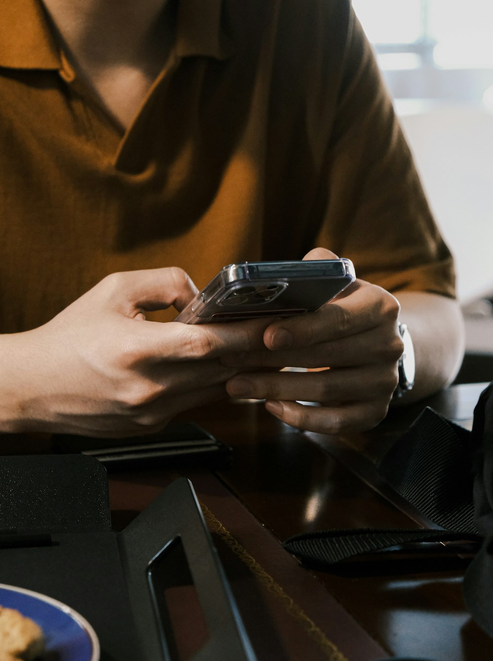 a person sitting at a table using a cell phone