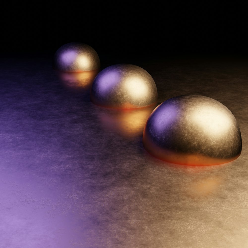 three shiny metal balls on a shiny surface
