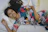 Photo of a smiling woman holding a colorful handblock print bedsheet in a cozy bedroom.