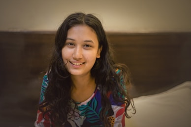 Portrait of a warm, approachable woman in a cozy home setting with natural light.