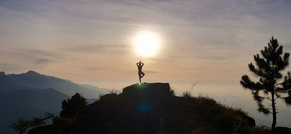 a person standing on top of a mountain with their arms in the air