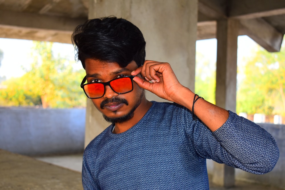 a man in a blue shirt and red sunglasses