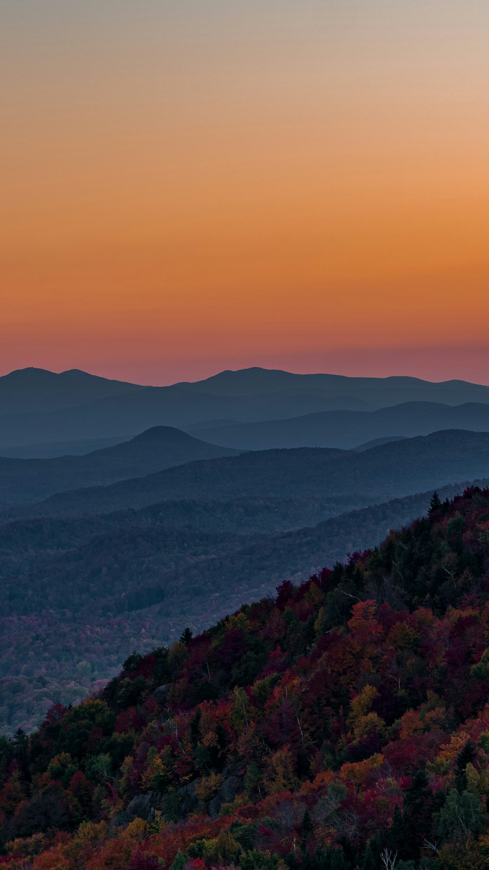 the sun is setting over the mountains in the distance