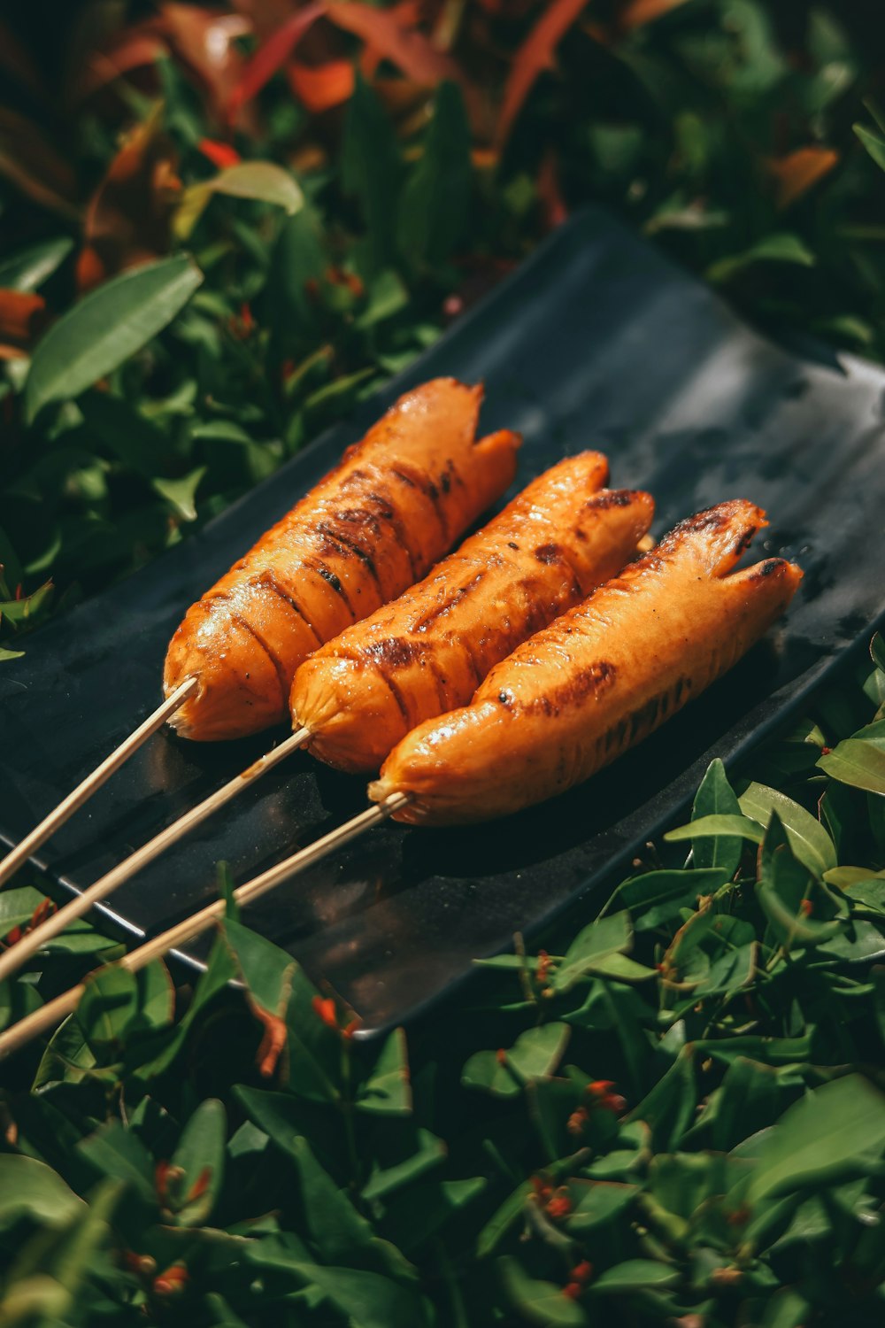 a couple of skewers of food sitting on top of a black plate