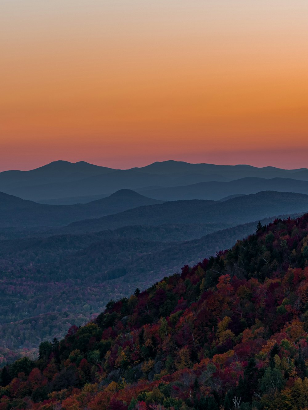 the sun is setting over the mountains in the fall